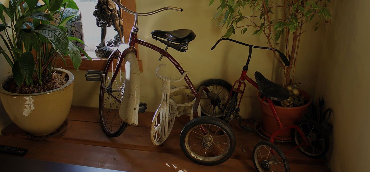 Old tricycles by the window inside the cafe